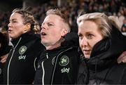 21 February 2025; Republic of Ireland assistant head coach Alan Mahon stand for the playing of the National Anthem with head coach Carla Ward, right, and goalkeeping coach Emma Byrne, left, before the UEFA Women's Nations League B match between Republic of Ireland and Turkiye at Tallaght Stadium in Dublin. Photo by Stephen McCarthy/Sportsfile