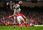 22 February 2025; Mack Hansen of Ireland offloads the ball as he is tackled by Tomos Williams of Wales during the Guinness Six Nations Rugby Championship match between Wales and Ireland at the Principality Stadium in Cardiff, Wales. Photo by Ben McShane/Sportsfile