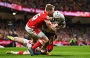 22 February 2025; Mack Hansen of Ireland is tackled by Blair Murray, 15, and Joe Roberts of Wales during the Guinness Six Nations Rugby Championship match between Wales and Ireland at the Principality Stadium in Cardiff, Wales. Photo by Ben McShane/Sportsfile