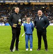 22 February 2025; Layla Quinn, St Eithne’s GNS, Edenmore, with Damian Bradfield, Customer Relationship Executive Allianz, left, and James Hayden, Chairman, Cumann na mBunscol, during half-time of the Allianz Football League Division 1 match between Dublin and Derry at Croke Park in Dublin. Photo by Piaras Ó Mídheach/Sportsfile