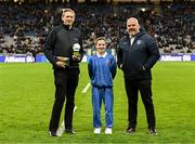 22 February 2025; Layla Quinn, St Eithne’s GNS, Edenmore, with Damian Bradfield, Customer Relationship Executive Allianz, left, and James Hayden, Chairman, Cumann na mBunscol, during half-time of the Allianz Football League Division 1 match between Dublin and Derry at Croke Park in Dublin. Photo by Piaras Ó Mídheach/Sportsfile