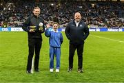 22 February 2025; Layla Quinn, St Eithne’s GNS, Edenmore, with Damian Bradfield, Customer Relationship Executive Allianz, left, and James Hayden, Chairman, Cumann na mBunscol, during half-time of the Allianz Football League Division 1 match between Dublin and Derry at Croke Park in Dublin. Photo by Piaras Ó Mídheach/Sportsfile