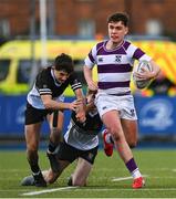 27 February 2025; Tom English of Clongowes Wood College evades the tackle of Newbridge College players Jack Scott, left, and Ryan Crawford during the Bank of Ireland Leinster Rugby Boys Schools Junior Cup second round match between Clongowes Wood College and Newbridge College at Energia Park in Dublin. Photo by Shauna Clinton/Sportsfile