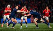 28 February 2025; Calvin Nash of Munster is tackled by Paul Hill, left, and Ben Muncaster of Edinburgh during the United Rugby Championship match between Munster and Edinburgh at Virgin Media Park in Cork. Photo by Tyler Miller/Sportsfile