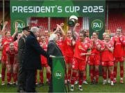 1 March 2025; Shelbourne captian Pearl Slattery is presented with the FAI President's Cup by President of Ireland Michael D Higgins and FAI President Paul Cooke, left, after the 2025 Women's President's Cup match between Shelbourne and Athlone Town at Tolka Park in Dublin. Photo by Stephen McCarthy/Sportsfile