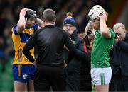 2 March 2025; Team captains Tony Kelly, left, and Cian Lynch of Limerick affix their helmets as they listen to final words from referee Thomas Walsh before the Allianz Hurling League Division 1A match between Limerick and Clare at TUS Gaelic Grounds in Limerick. Photo by Brendan Moran/Sportsfile