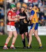 9 March 2025; Linesman Shane Hynes breaks up a tussle between Cathal McCarthy of Cork in action against David Fitzgerald of Clare during the Allianz Hurling League Division 1A match between Clare and Cork at Zimmer Biomet Páirc Chíosóg in Ennis, Clare.  Photo by John Sheridan/Sportsfile