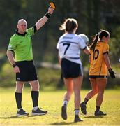 14 March 2025; Referee Shane Curley shows a yellow card to Clodagh Lohan of DCU DÉ during the 2025 Ladies AIG HEC O'Connor Cup semi-final match between DCU Dóchas Éireann and UU Belfast at Queen's Sport, Queens University, Belfast. Photo by Shauna Clinton/Sportsfile