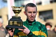 14 March 2025; Jockey Mark Walsh holds the Boodles Cheltenham Gold Cup after winning the Boodles Cheltenham Gold Cup Steeple Chase, with Inothewayurthinkin, on day four of the Cheltenham Racing Festival at Prestbury Park in Cheltenham, England. Photo by David Fitzgerald/Sportsfile