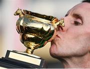 14 March 2025; Jockey Mark Walsh kisses the Boodles Cheltenham Gold Cup after winning the Boodles Cheltenham Gold Cup Steeple Chase, with Inothewayurthinkin, on day four of the Cheltenham Racing Festival at Prestbury Park in Cheltenham, England. Photo by David Fitzgerald/Sportsfile