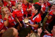 15 March 2025; MTU Cork captain Rachael Evans celebrates with her teammates and the Lynch Cup after the 2025 Ladies AIG Lynch final match between MTU Cork and UCD at Queen's Sport, Queens University, Belfast. Photo by Ben McShane/Sportsfile
