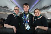 16 March 2025; Donal Brennan of Team Ireland, a member of Kilternan Karvers, Ballinteer, Dublin, with Sinéad Curran, left, Line Standards Supervisor, and Geri Cunningham, Cabin Crew, on the Aer Lingus flight to Dublin after competing in the Turin 2025 Special Olympics World Winter Games in Italy. Photo by Ray McManus/Sportsfile