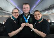 16 March 2025; Bronze Medal winner Joseph 'Joe-Joe' Sheehan of Team Ireland, a member of Mallow Special Olympics Club, Doneraile, Cork, with Sinéad Curran, left, Line Standards Supervisor, and Geri Cunningham, Cabin Crew, on the Aer Lingus flight to Dublin after competing in the Turin 2025 Special Olympics World Winter Games in Italy. Photo by Ray McManus/Sportsfile