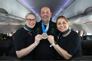 16 March 2025; Bronze Medal winner Damien Kirwan of Team Ireland, a member of Waterford Special Olympics Club, Waterford City, with Sinéad Curran, left, Line Standards Supervisor, and Geri Cunningham, Cabin Crew, on the Aer Lingus flight to Dublin after competing in the Turin 2025 Special Olympics World Winter Games in Italy. Photo by Ray McManus/Sportsfile