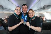 16 March 2025; Silver and Bronze Medal winner Clive Healy of Team Ireland, a member of Waterford Special Olympics Club, Waterford City with Sinéad Curran, left, Line Standards Supervisor, and Geri Cunningham, Cabin Crew, on the Aer Lingus flight to Dublin after competing in the Turin 2025 Special Olympics World Winter Games in Italy. Photo by Ray McManus/Sportsfile