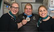 16 March 2025; Bronze Medal winner James Upton of Team Ireland, a member of Waterford Special Olympics Club, Passage East, Waterford, with Sinéad Curran, left, Line Standards Supervisor, and Geri Cunningham, Cabin Crew, on the Aer Lingus flight to Dublin after competing in the Turin 2025 Special Olympics World Winter Games in Italy. Photo by Ray McManus/Sportsfile