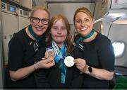 16 March 2025; Gold and Bronze medal winner Maire Connelly of Team Ireland, a member of Kilternan Karvers, Clanbridge, Galway with Sinéad Curran, left, Line Standards Supervisor, and Geri Cunningham, Cabin Crew, on the Aer Lingus flight to Dublin after competing in the Turin 2025 Special Olympics World Winter Games in Italy. Photo by Ray McManus/Sportsfile