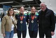 17 March 2025; Aoife, right, and Lisa O’Rourke of Ireland with the silver medals they won in their respective Elite Women 70-75kg middleweight and 66-70kg light middleweight final bouts at the 2025 IBA Women's World Boxing Championships finals are congratulated by mam, Ann, and dad, Kevin, upon their arrival at Dublin Airport from the IBA Women's World Boxing Championships in Niš, Serbia. Photo by Ray McManus/Sportsfile
