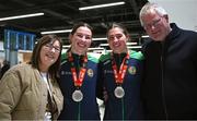 17 March 2025; Aoife, right, and Lisa O’Rourke of Ireland with the silver medals they won in their respective Elite Women 70-75kg middleweight and 66-70kg light middleweight final bouts at the 2025 IBA Women's World Boxing Championships finals are congratulated by mam, Ann, and dad, Kevin, upon their arrival at Dublin Airport from the IBA Women's World Boxing Championships in Niš, Serbia. Photo by Ray McManus/Sportsfile