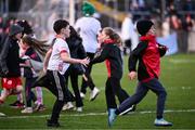 23 March 2025; Children run on the pitch after the hooter went thinking the game was over during the Allianz Football League Division 1 match between Tyrone and Dublin at O'Neills Healy Park in Omagh, Tyrone. Photo by Ray McManus/Sportsfile
