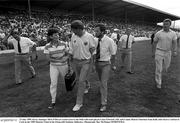 23 July 1989; Kerry manager Mick O'Dwyer, centre, leaves the field with team physio Clare Edwards, left, and County Board Chairman Sean Kelly after Kerry's defeat to Cork in the 1989 Munster Final at the Fitzgerald Stadium, Killarney. Photograph: Ray McManus SPORTSFILE.