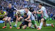 5 April 2025; Ross Byrne of Leinster scores his side's eighth try despite the efforts of Jamie Benson of Harlequins during the Investec Champions Cup Round of 16 match between Leinster and Harlequins at Croke Park in Dublin. Photo by Sam Barnes/Sportsfile