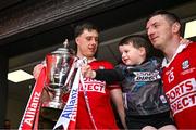 6 April 2025; Cork captain Robert Downey, left, and teammate Patrick Horgan, with his son Jack, and the cup after the Allianz Hurling League Division 1A final match between Tipperary and Cork at SuperValu Páirc Uí Chaoimh in Cork. Photo by Brendan Moran/Sportsfile