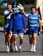 7 April 2025; Lee Barron, left, and John McKee, right, provide cover to team-mate Scott Penny as they arrive for Leinster Rugby squad training at UCD in Dublin. Photo by Piaras Ó Mídheach/Sportsfile