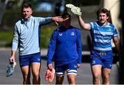 7 April 2025; Lee Barron, left, and John McKee, right, provide cover to team-mate Scott Penny as they arrive for Leinster Rugby squad training at UCD in Dublin. Photo by Piaras Ó Mídheach/Sportsfile