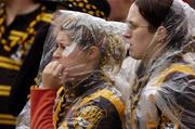 12 September 2004; Kilkenny fans shelter from the rain during the final stages of the game. Guinness All-Ireland Senior Hurling Championship Final, Cork v Kilkenny, Croke Park, Dublin. Picture credit; Ray McManus / SPORTSFILE *** Local Caption *** Any photograph taken by SPORTSFILE during, or in connection with, the 2004 Guinness All-Ireland Hurling Final which displays GAA logos or contains an image or part of an image of any GAA intellectual property, or, which contains images of a GAA player/players in their playing uniforms, may only be used for editorial and non-advertising purposes.  Use of photographs for advertising, as posters or for purchase separately is strictly prohibited unless prior written approval has been obtained from the Gaelic Athletic Association.