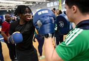 10 April 2025; Olympic athletes Kellie Harrington and Philip Doyle, along with Paralympian Orla Comerford, who are all Dare to Believe ambassadors, attended the Dare to Believe booth at PE Expo 2025, sponsored by Allianz, at the Sport Ireland National Indoor Arena in Dublin. Pictured at the Dare to Believe PE Expo 2025 is Fahad Sulaimon hitting pads held by boxer Adam Hession. Photo by David Fitzgerald/Sportsfile