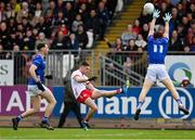13 April 2025; Niall Devlin of Tyrone kicks his side's opening point under pressure from Oisin Kiernan of Cavan during the Ulster GAA Football Senior Championship quarter-final match between Tyrone and Cavan at O'Neills Healy Park in Omagh, Tyrone. Photo by Ramsey Cardy/Sportsfile