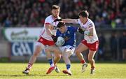 13 April 2025; Cian Reilly of Cavan is tackled by Peter Teague, left, and Ruairí Canavan of Tyrone during the Ulster GAA Football Senior Championship quarter-final match between Tyrone and Cavan at O'Neills Healy Park in Omagh, Tyrone. Photo by Ramsey Cardy/Sportsfile