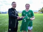 17 April 2025; Ruby Boland of Republic of Ireland is presented with her jersey by Republic of Ireland head coach Richard Berkeley after the Girls U15 SAFIB Bob Docherty Cup match between Northern Ireland and Republic of Ireland at Greenisland FC in Antrim. Photo by Seb Daly/Sportsfile