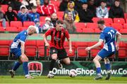 19 April 2025; Glenn Towler of Ringmahon Rangers FC in action against College Corinthians AFC players Andrew Neville, left, and Killian Cooper during the FAI Intermediate Cup final match between College Corinthians AFC and Ringmahon Rangers FC at Turners Cross Stadium in Cork. Photo by Michael P Ryan/Sportsfile