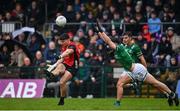 19 April 2025; Daniel Guinness of Down kicks a point under pressure from Ryan Lyons of Fermanagh during the Ulster GAA Football Senior Championship quarter-final match between Fermanagh and Down at Brewster Park in Enniskillen, Fermanagh. Photo by Ramsey Cardy/Sportsfile