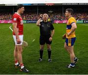 20 April 2025; Robert Downey of Cork and Tony Kelly of Clare look on as referee Liam Gordon tosses the coin before the Munster GAA Hurling Senior Championship Round 1 match between Clare and Cork at Zimmer Biomet Páirc Chíosóg in Ennis, Clare. Photo by John Sheridan/Sportsfile