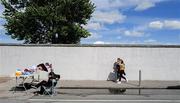 26 April 2025; Two Offaly supporters make their way to the game as a flagseller rests before the Leinster GAA Hurling Senior Championship Round 2 match between Offaly and Galway at Glenisk O’Connor Park in Tullamore, Offaly. Photo by Ray McManus/Sportsfile