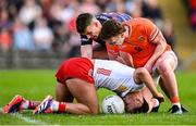 26 April 2025; Michael McKernan of Tyrone tussles with Armagh players Ross McQuillan, right, and goalkeeper Ethan Rafferty during the Ulster GAA Football Senior Championship semi-final match between Armagh and Tyrone at St Tiernach's Park in Clones, Monaghan. Photo by Seb Daly/Sportsfile