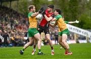 27 April 2025; John McGeough of Down is tackled by Stephen McMenamin, left, and Finnbarr Roarty of Donegal during the Ulster GAA Football Senior Championship semi-final match between Down and Donegal at St Tiernach's Park in Clones, Monaghan. Photo by Ben McShane/Sportsfile