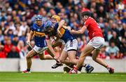 27 April 2025; John McGrath of Tipperary is tackled by Robert Downey and Eoin Downey of Cork during the Munster GAA Hurling Senior Championship Round 2 match between Cork and Tipperary at SuperValu Páirc Uí Chaoimh in Cork. Photo by Brendan Moran/Sportsfile