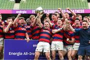 27 April 2025; Dylan Donnellan captain of Clontarf lifts the cup as his team-metes celebrate after the Energia All-Ireland League Men's Division 1A final match between Clontarf and Cork Constitution at the Aviva Stadium in Dublin. Photo by Matt Browne/Sportsfile