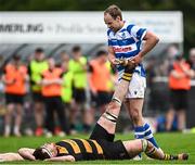 27 April 2025; Craig Miller of Athy helps County Carlow captain John Lyons with cramp during the Bank of Ireland Provincial Towns Cup final match between Athy RFC and County Carlow FC at Forenaughts in Naas, Kildare. Photo by Seb Daly/Sportsfile