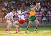 30 April 2025; Conor McGinty of Donegal in action against Caolan Donnelly, left, and Callum Daly of Tyrone during the Dalata Hotel Group Ulster GAA Football U20 Championship final match between Donegal and Tyrone at Owenbeg Derry GAA Centre in Dungiven, Derry. Photo by Piaras Ó Mídheach/Sportsfile