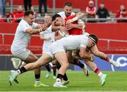 9 May 2025; Calvin Nash of Munster is tackled by Ulster players, Jude Postlethwaite, Jacob Stockdale and Stuart McCloskey during the United Rugby Championship match between Munster and Ulster at Thomond Park in Limerick. Photo by John Dickson/Sportsfile