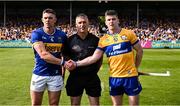 10 May 2025; Referee James Owens stands between the two captains, Ronan Maher of Tipperary and Tony Kelly of Clare, before the Munster GAA Hurling Senior Championship Round 3 match between Clare and Tipperary at Zimmer Biomet Páirc Chíosóg in Ennis, Clare. Photo by Ray McManus/Sportsfile