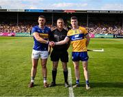 10 May 2025; Referee James Owens stands between the two captains, Ronan Maher of Tipperary and Tony Kelly of Clare, before the Munster GAA Hurling Senior Championship Round 3 match between Clare and Tipperary at Zimmer Biomet Páirc Chíosóg in Ennis, Clare. Photo by Ray McManus/Sportsfile