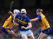 14 May 2025; Adam Ryan of Tipperary is tackled by Clare players, from left, Fred Hegarty and Sean Boyce during the oneills.com Munster GAA Hurling U20 Championship final match between Tipperary and Clare at TUS Gaelic Grounds in Limerick. Photo by John Sheridan/Sportsfile