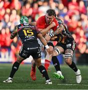 16 May 2025; Peter O'Mahony of Munster is tackled by Rhyno Smith and Riccardo Favretto of Benetton Treviso during the United Rugby Championship match between Munster and Benetton at Virgin Media Park in Cork. Photo by Brendan Moran/Sportsfile