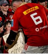 16 May 2025; Munster supporter Tadhg Daly, from Dungarvan in Waterford, watches as Peter O'Mahony of Munster signs an autograph on his poster after the United Rugby Championship match between Munster and Benetton at Virgin Media Park in Cork. Photo by Brendan Moran/Sportsfile